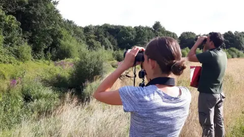 Weald to Waves People using binoculars in field