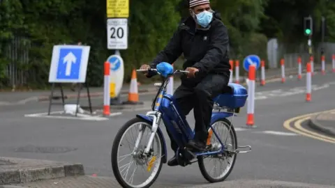 EPA A cyclist wearing a facemask in Leicester