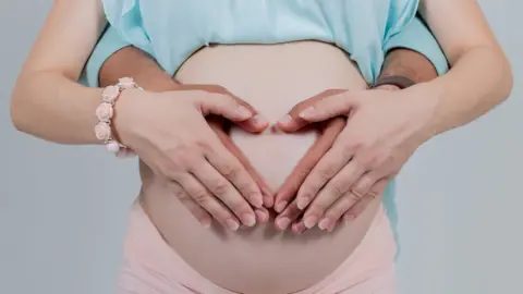 Murat Deniz/Getty Images Pregnant woman with hands around her bump