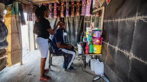 BBC/Shiraaz Mohamed Nelfalda Dule in her hairdresser shack in Alexandra township - Johannesburg, South Africa