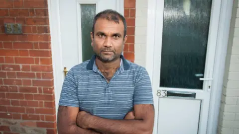 Peter Forthergill Abdul Kadva outside the houses