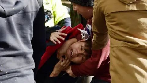 EPA A pro-democracy demonstrator holding a Taiwanese flag clashes with pro-China supporters in Sydney