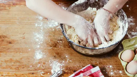 Getty Images Hands in bowl of dough