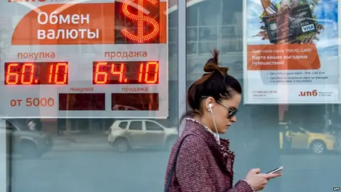 AFP woman walks past a currency exchange office in Moscow