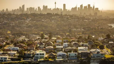 Getty Images Aerial photography of Sydney skyline with suburb and houses on costal sea cliff in the forefront.