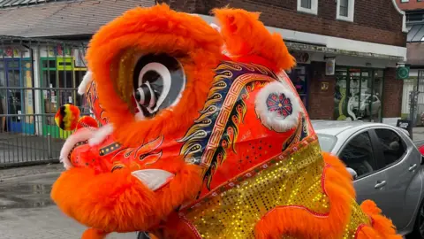 The orange decorated head of lion costume used for the traditional dance