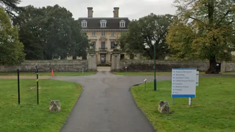 Google Thorpe Hall Hospice- historic building with a concrete driveway leading up to the big house 