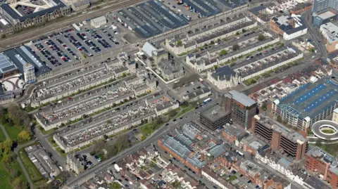 An aerial view of Swindon's Railway Village. It is a large built up residential area with hundreds of houses, flats and a large car park. 