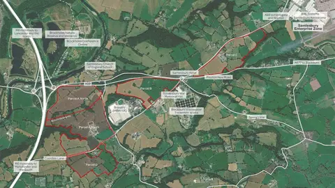 Story Homes/Turley Ariel view of the proposed Cuerdale Garden Village site, showing a large area of fields and major roads in white with large areas marked out with red boundaries