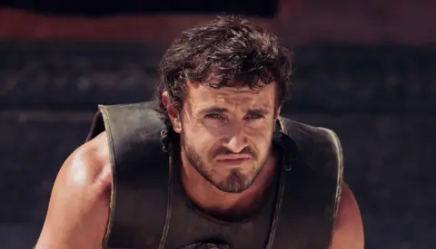 Paramount Pictures Paul Mescal in Gladiator II - he is sternly looking at the camera while wearing gladiator body armour