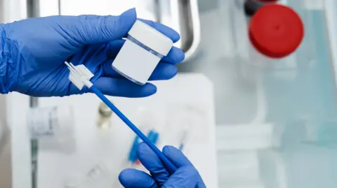 Gynecologist holds a flask for cytology Pap smear 