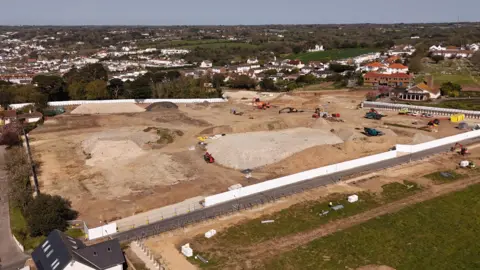 A drone photo of the building site at Overdale, with diggers and other construction vehicles visible, along with mounds of dirt. 