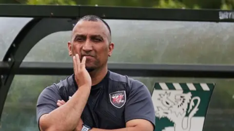 George Akhtar Man with short hair wearing a football shirt