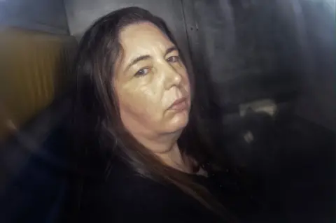Erin Patterson sitting in the back of a police van