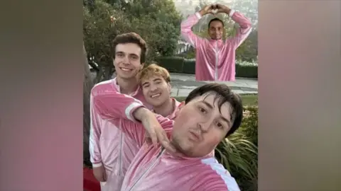 Boy Throb posing for a photo in pink tracksuits.