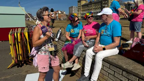 A journalist interviews three people sitting down.