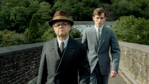 Severn Screen Toby Jones and Harry Lawtey cross Y Bont Mawr bridge in Pontrhydyfen, Neath Port Talbot, in one of the scenes from the film Mr Burton