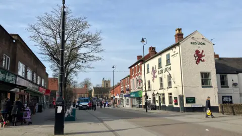 BBC Hucknall High Street showing a traditional pub and series of Victorian buildings on one side, then more modern flat roofed units on the other side