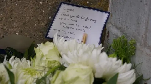 White flowers that were made to tribute with a message thanked Layton for "illuminate our life"