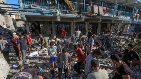 Palestijnse EPA inspecteert de schade aan een deel van de door de VN beheerde al-Jaouni-school in het vluchtelingenkamp Nuseirat, centraal Gaza, na een Israëlische luchtaanval (11 september 2024)