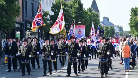Pacemaker Members of the Royal Black Institution carrying flags and marching down a street in Holywood