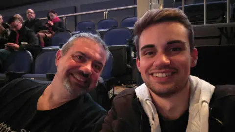 A selfie of Daniel and his dad in a cinema.