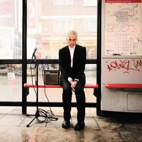 Last night from Glasgow, the cover of album sweet confusion shows Peter Capledi in a black suit and a microphone stand on a bus shelter seat in London and AMP next to it