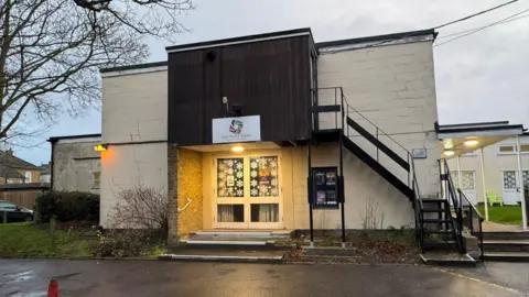 The entrance of the Sarah Thorne Theatre - a large, white building made from big bricks.