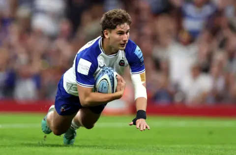 Bath's Ciaran Donoghue scores the opening try of the game against Bristol in Cardiff. He is wearing the Bath change kit of white with blue sleeves