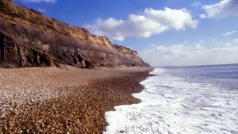 A sunny day by Hengistbury Head's coast. There is no one on the beach.