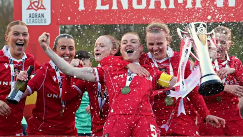 Wrexham players celebrate winning the Genero Adran Premier title