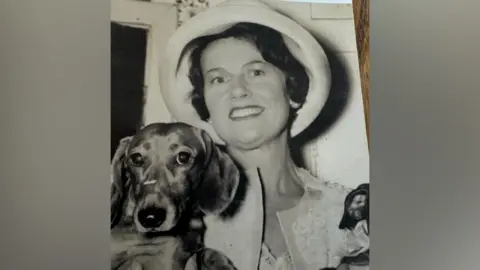 Mark Dyer  Muriel McKay holding her pet dachshund 