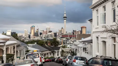 Getty Images An Auckland street with the city skyline and grey storm clouds in the background