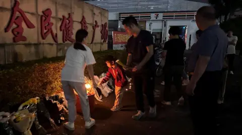 Reuters Mourners laid flowers outside the stadium in Zhuhai after the attack