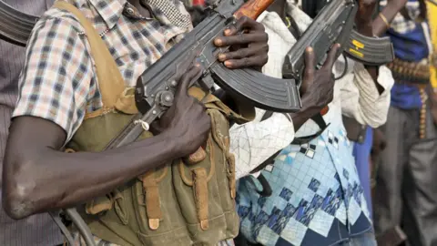 A close-up shot of young men in Nasir belonging to the White Army holding guns - archive shot.