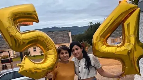 Family handout Two women with dark hair holding up a '5' and '4' balloons.
