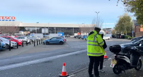 The officer standing next to the rider