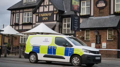 A forensic van is parked outside a pub, with a police cordon in place.