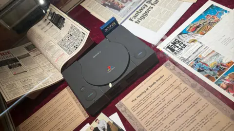 A black playstation console in a display cabinet