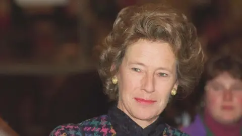 Getty Images Dame Shân pictured with brown hair, gold earrings and multi-coloured tweed coat.