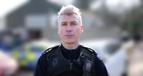 Tano Grima from Home Office immigration enforcement standing outside a building where people were questioned by immigration staff