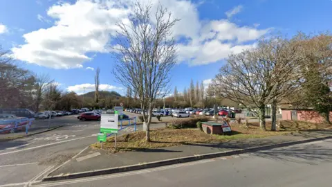 Google A carpark surrounded by trees. A sign reads Coypool Park and Ride Car Park.