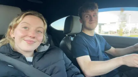 Katie Bain A selfie taken in a care by Katie of herself and her partner Ben, who is driving.