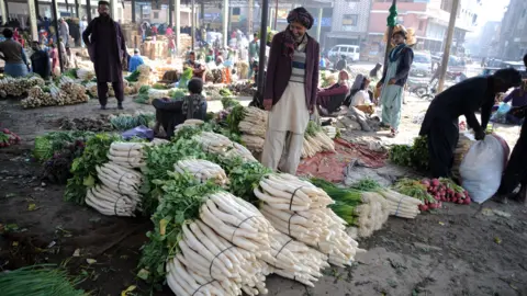 A man stands in front of produce in Pakistan