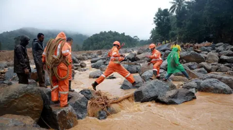 Reuters Rescue team members move to the landslide site after multiple landslides in the hills of Wayanad