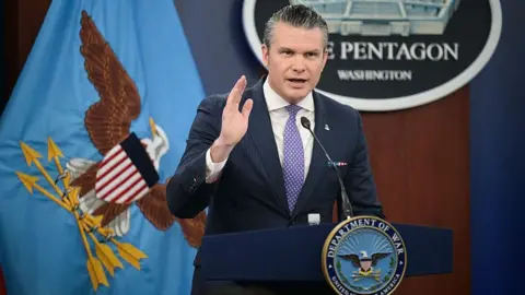 Pete Hegseth delivers a briefing behind a lectern at the Pentagon