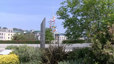 BBC The Liberation Monument with buildings and the memorial mast behind