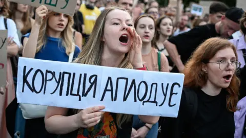 Protesters in Kyiv, Ukraine seen with placards demonstrating against a law that strips two anti-corruption bodies of their independence on 22 July, 2025.