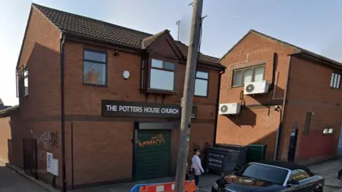 A church that looks like a dark brick, modern detached house 