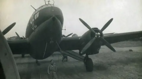 Joanna Burri-Weaver Black and White image of Peter Weaver standing in front of an aircraft before flying to Norway in May 1945.

